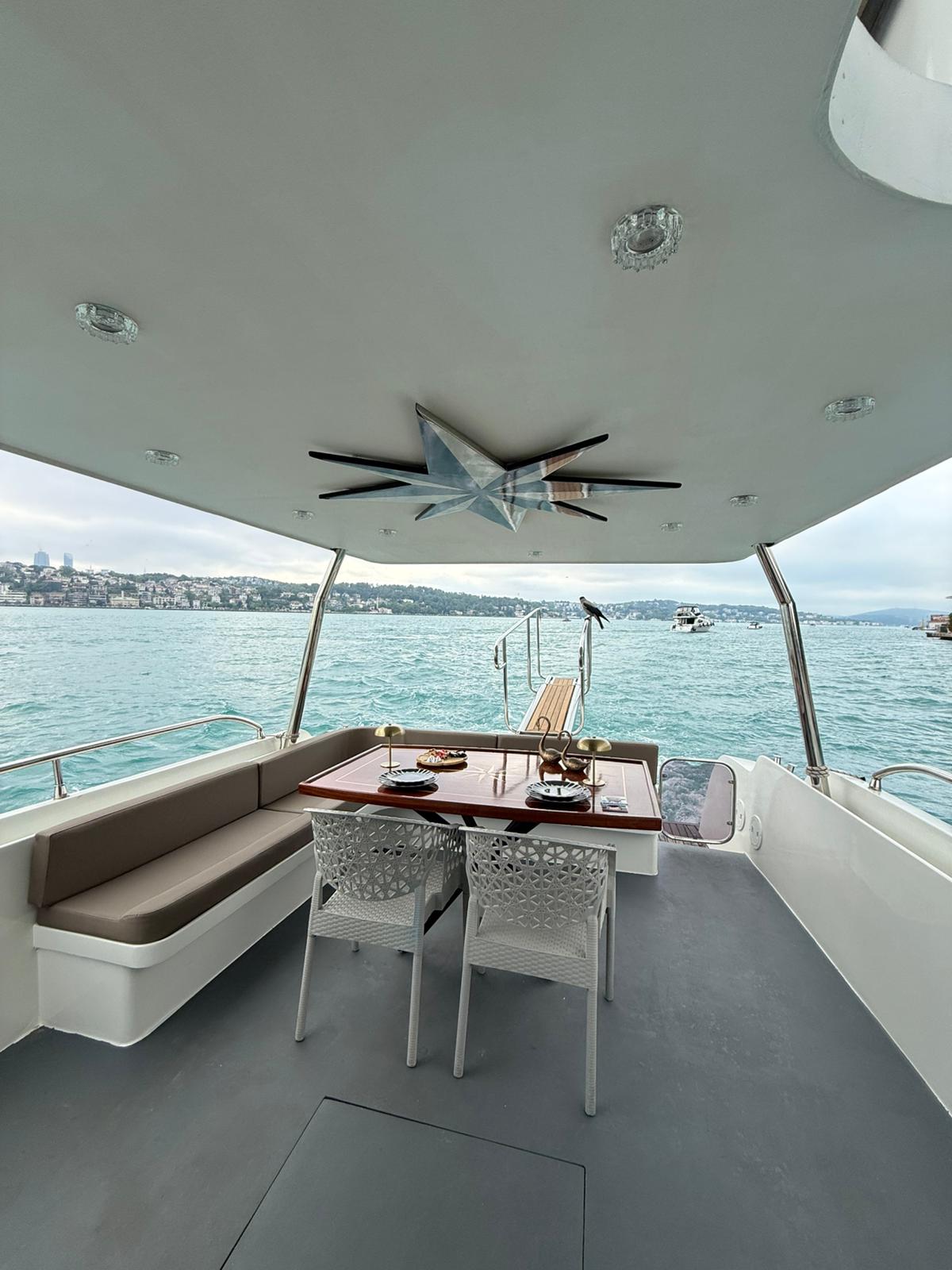 interior of a high-end luxury yacht with cream leather sofas, polished wood, and panoramic windows showing the bosphorus
